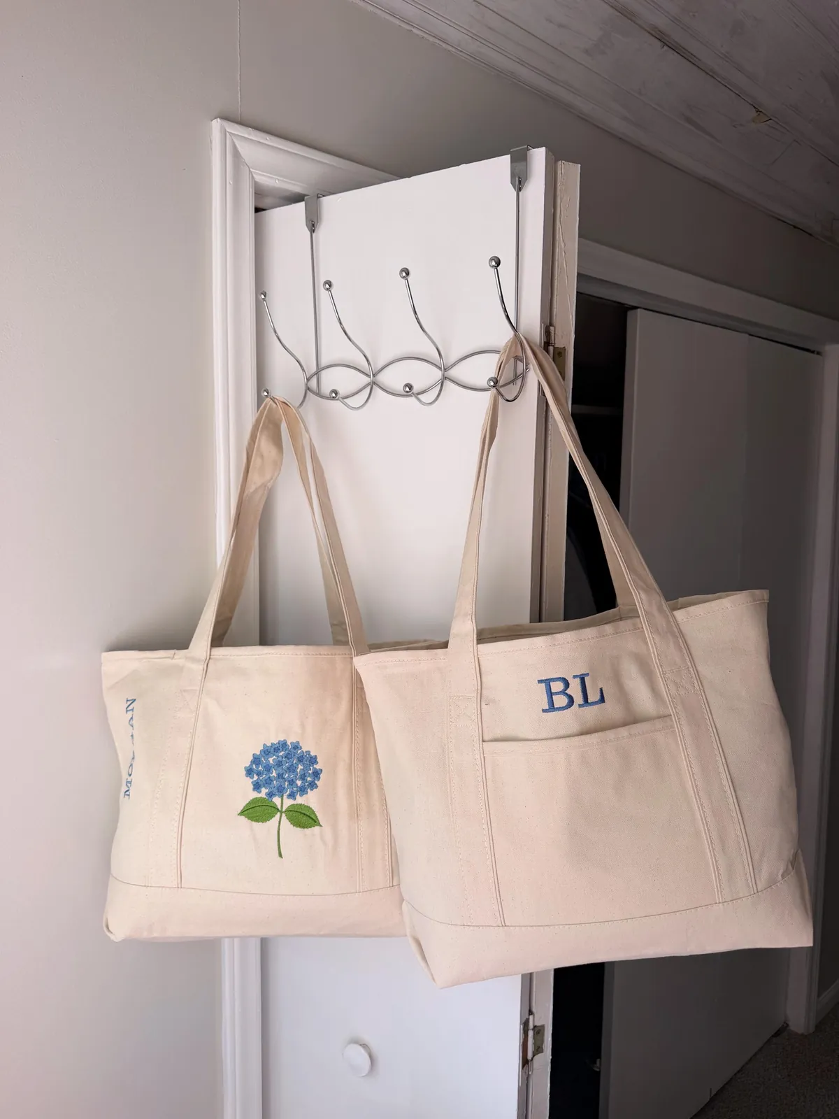 Monogram and Hydrangea totes hanging on a door